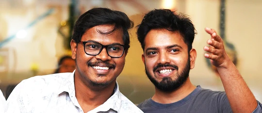 Two smiling team members at a company event