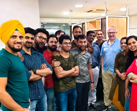 Team members posing together in an office during a group photo