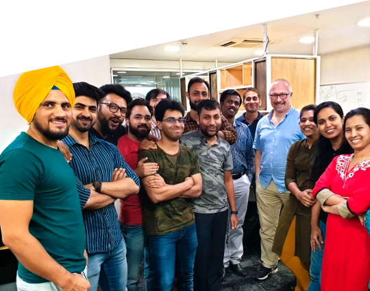 Team members posing together in an office during a group photo