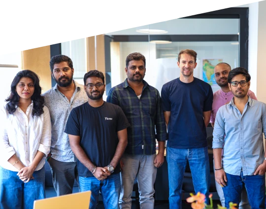 Group of coworkers posing together in a bright office environment