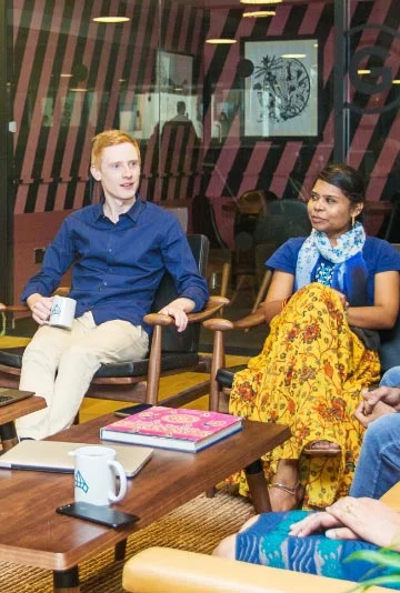 Group of people sitting office couches and table