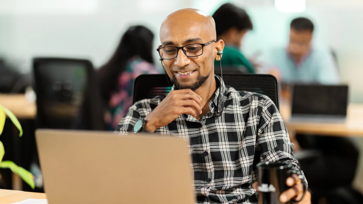 man smiling desk work laptop