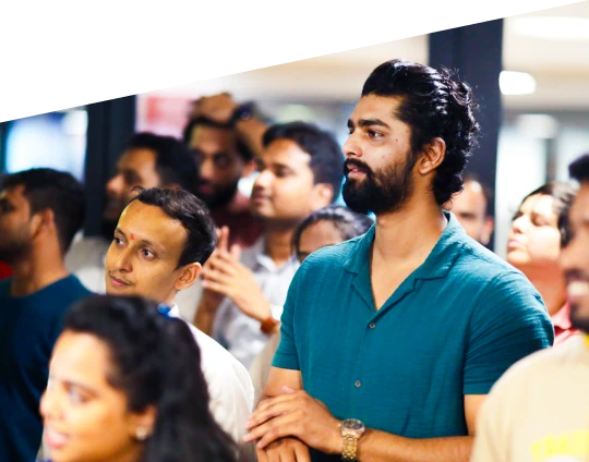 People gathered indoors during a team event, listening attentively