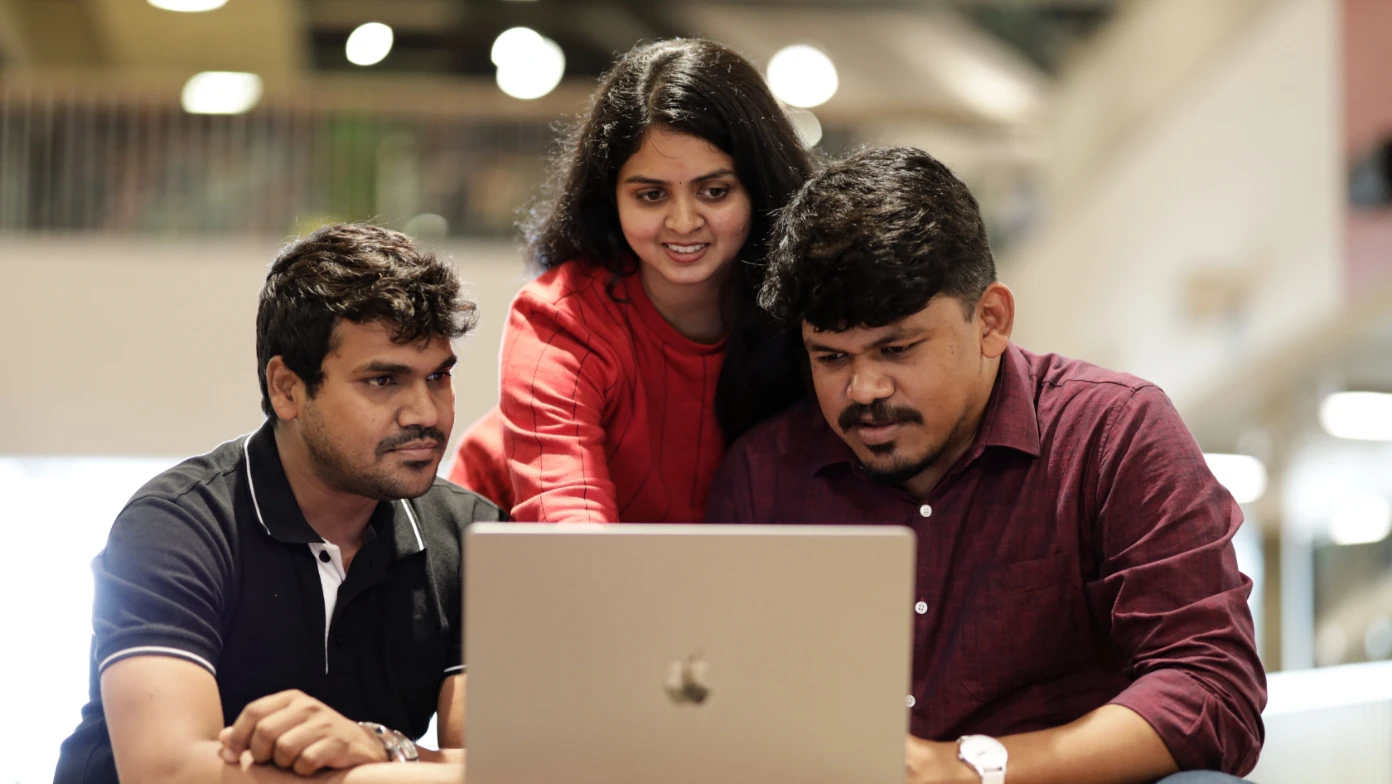 two men and a woman are looking at the code