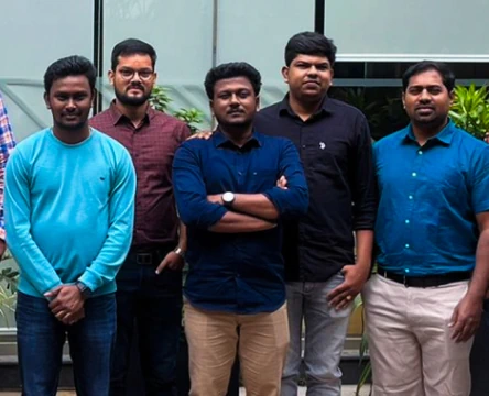 A group of coworkers posing for a photo outside an office building
