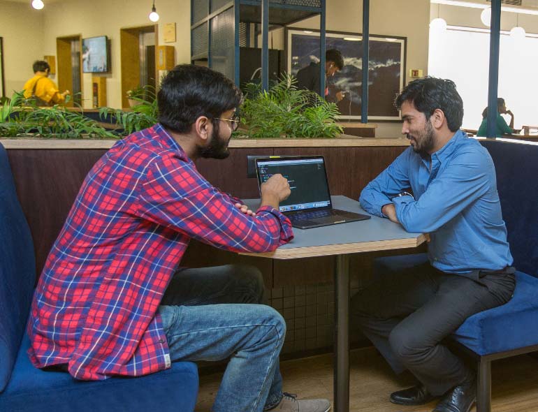 two mans sitting at the table chatting