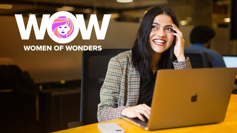 smiling woman uses a laptop