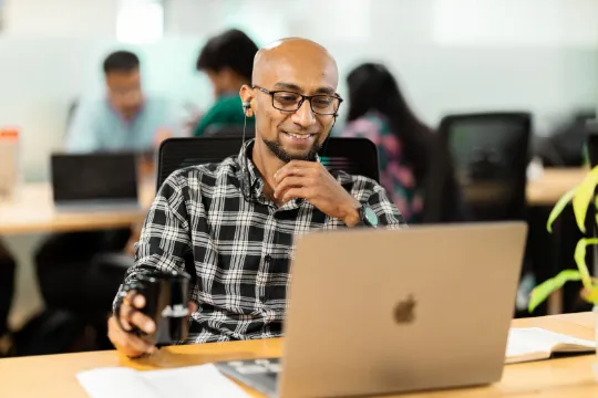 man smiling desk work laptop