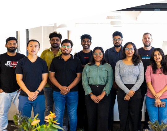 Team photo of employees standing together in a modern office