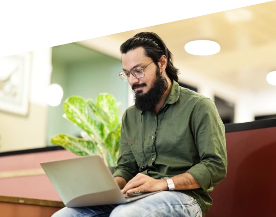 a person sitting and typing on a laptop