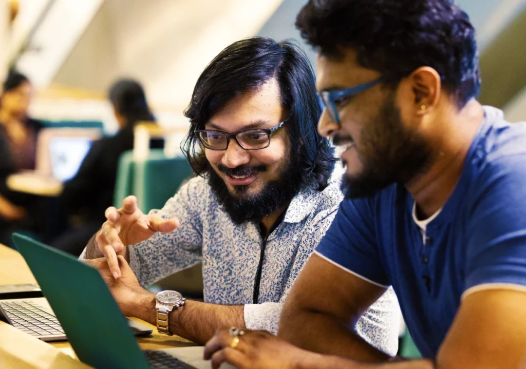 two people working together and smiling