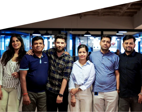 a group of people standing together indoors in an office environment