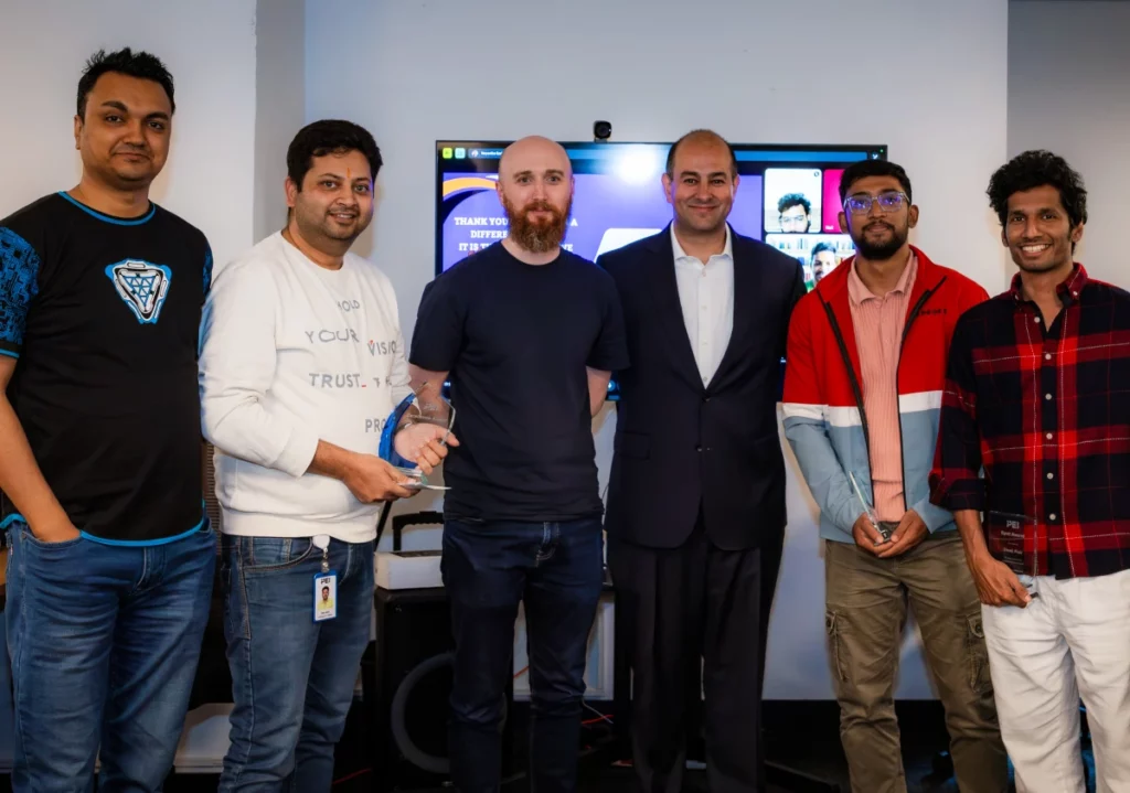 six colleagues posing together in an office