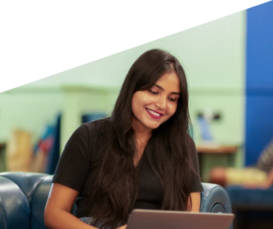 Smiling woman working on a laptop while sitting on a couch