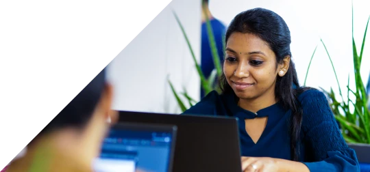 Technology professional working on a laptop in a modern office