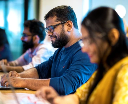 Team members working on laptops in an office