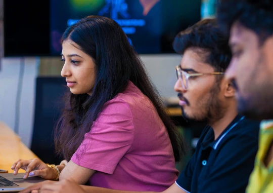 A group of people working on laptops in an office
