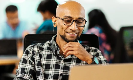 man working on a laptop at his desk