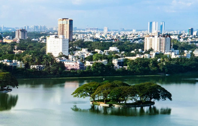 View of Bangalore skyline with a small tree-covered island on the lake