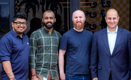 Team members posing together outside a modern office