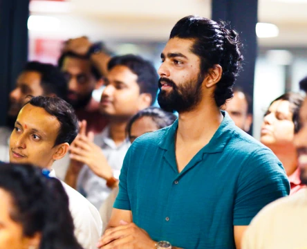 People gathered indoors during a team event, listening attentively
