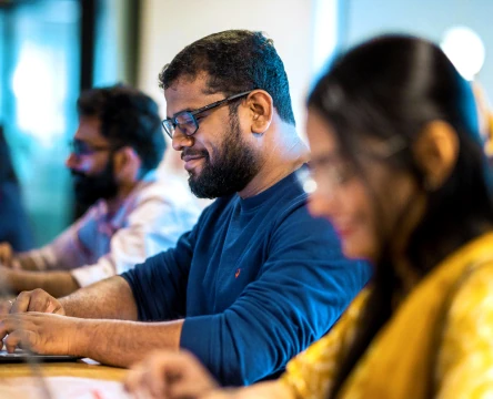 Team members working on laptops in a modern office
