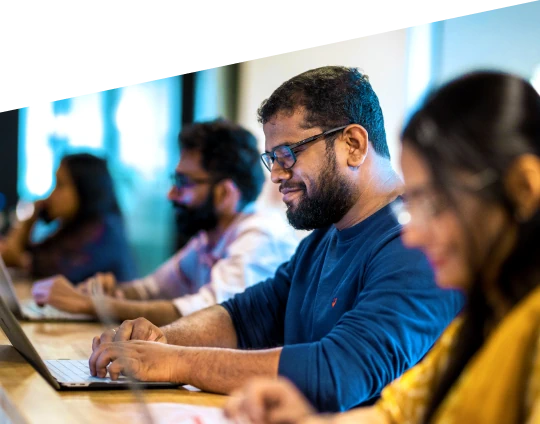 Team members working on laptops in a modern office